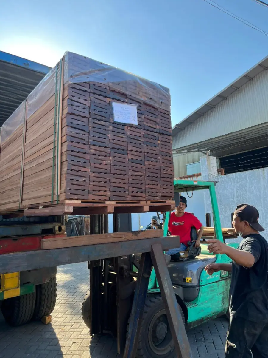 Forklift loading a timber bundle onto a truck